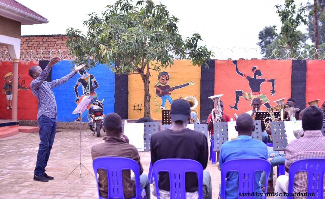 Freddie conducting the band in front of colourful murals