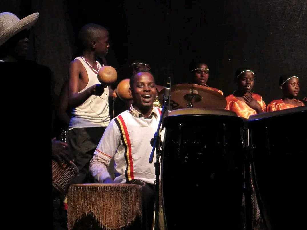 Children performing traditional music on stage under spotlights
