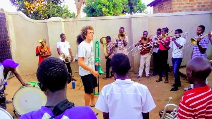 Volunteer conducting outdoor brass rehearsal with the band